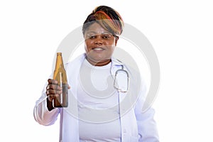 Studio shot of happy fat black African woman doctor smiling whil