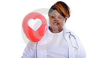 Studio shot of happy fat black African woman doctor smiling whil
