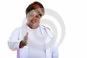 Studio shot of happy fat black African woman doctor smiling whil