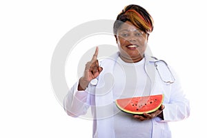 Studio shot of happy fat black African woman doctor smiling whil