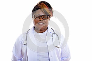 Studio shot of happy fat black African woman doctor smiling whil