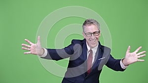 Studio shot of happy mature businessman with surprise gesture