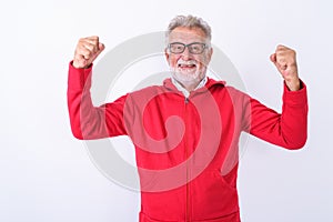 Studio shot of happy senior bearded man smiling while flexing bo