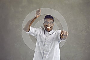 Studio shot of a happy young Afro American man dancing gangnam style and smiling