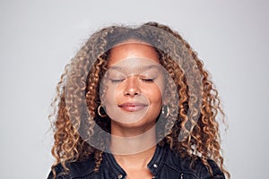 Studio Shot Of Happy Young Woman With Eyes Closed Daydreaming