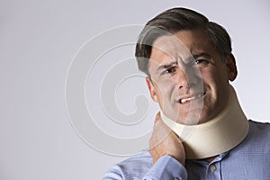 Studio Shot Of Man In Pain Wearing Neck Brace