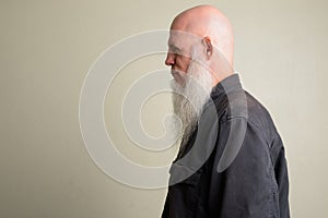Profile view of mature bald man with long gray beard