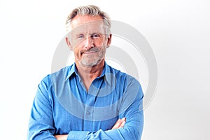 Studio Shot Of Mature Man Against White Background Smiling At Camera