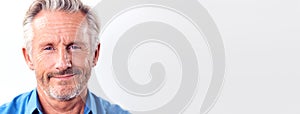 Studio Shot Of Mature Man Against White Background Smiling At Camera