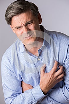 Studio Shot Of Mature Man Suffering Heart Attack