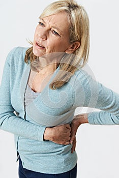 Studio Shot Of Mature Woman Suffering With Kidney Pain