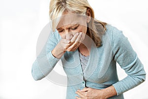 Studio Shot Of Mature Woman Suffering From Nausea