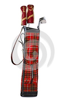 Studio shot of an old tartan golf bag and clubs on a white background.