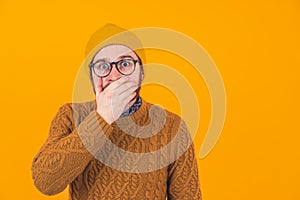 Studio shot on orange background of an isolated shocked scared surprised caucasian man looking at camera with his eyes