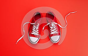 A studio shot of pair of canvas shoes on red background. Flat lay.