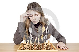 Studio Shot Of Pensive Young Girl Looking Down At Chessboard And Thinking Intensely About Chess Strategy Isolated On White