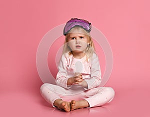 Studio shot of pleased beautiful little girl posing in eyemask photo