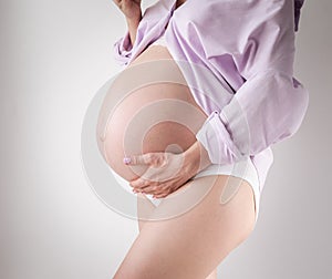 studio shot of a pregnant belly on a white background