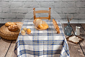 Studio shot of a scene from a room in a rural house. with a table with a retro checkered tablecloth, with flour, bread, muffins