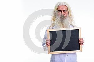 Studio shot of senior bearded man doctor holding blank blackboar