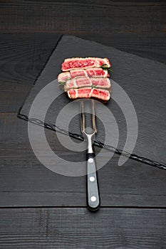 Studio shot of slices of steak on a meat fork