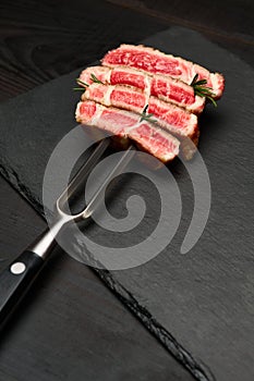 Studio shot of slices of steak on a meat fork