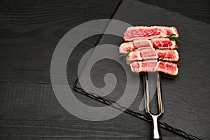 Studio shot of slices of steak on a meat fork