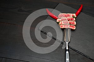 Studio shot of slices of steak on a meat fork