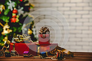 Studio shot of small and big red paper wrapped present gift boxes with gold and silver ribbon bow tie placed on wood table with