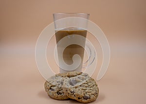 Studio shot of three layered tea drink and chocolate chip cookies with brown ombre background