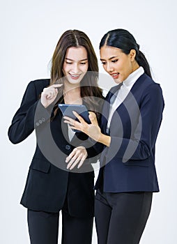 Studio shot of two Asian young beautiful female professional successful businesswoman model in formal business suit standing