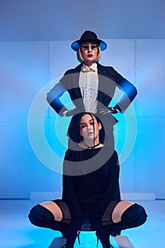 Studio shot of two flexible ladies dancers looking sexy, posing at camera, isolated