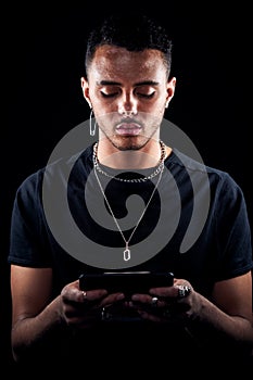 Studio Shot Of Unhappy Man Holding Mobile Phone Being Bullied Online