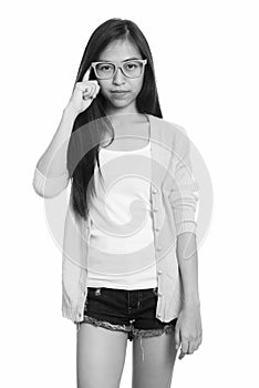 Studio shot of young Asian teenage girl with finger on head