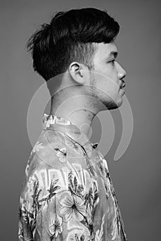 Young Asian tourist man ready for vacation against gray background