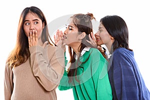 Studio shot of young Asian woman looking shocked with both frien