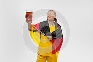 Studio shot of young astonished girl with german national flag supports favorite team. Soccer fans, emotions