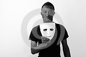 Studio shot of young black African man holding mask