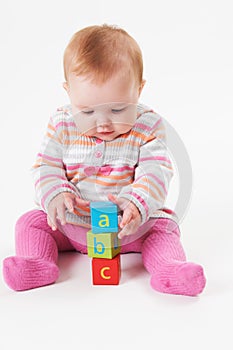 Studio Shot Of Young Girl Playing With Alphabet Blocks