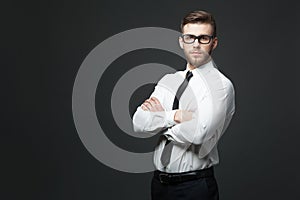 Studio shot of young handsome businessman on dark gray background.