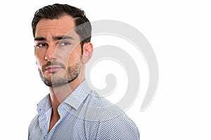 Studio shot of young handsome businessman thinking while looking