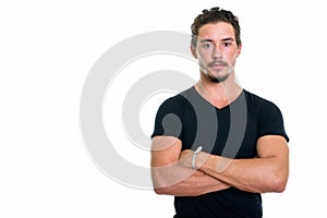 Studio shot of young handsome man with arms crossed isolated aga