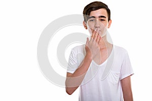 Studio shot of young handsome Persian teenage boy looking shocke