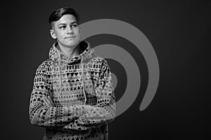 Studio shot of young handsome teenage boy against gray background