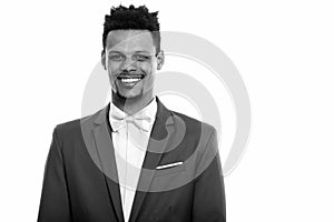 Studio shot of young happy African businessman smiling