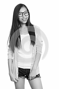 Studio shot of young happy Asian teenage girl smiling