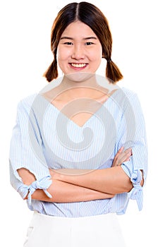 Studio shot of young happy Asian woman smiling with arms crossed