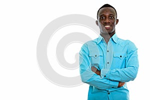 Studio shot of young happy black African man smiling with arms c