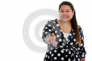 Studio shot of young happy fat Asian woman smiling while giving