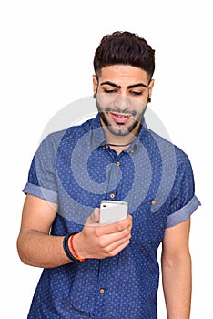 Studio shot of young happy Indian man using mobile phone isolate